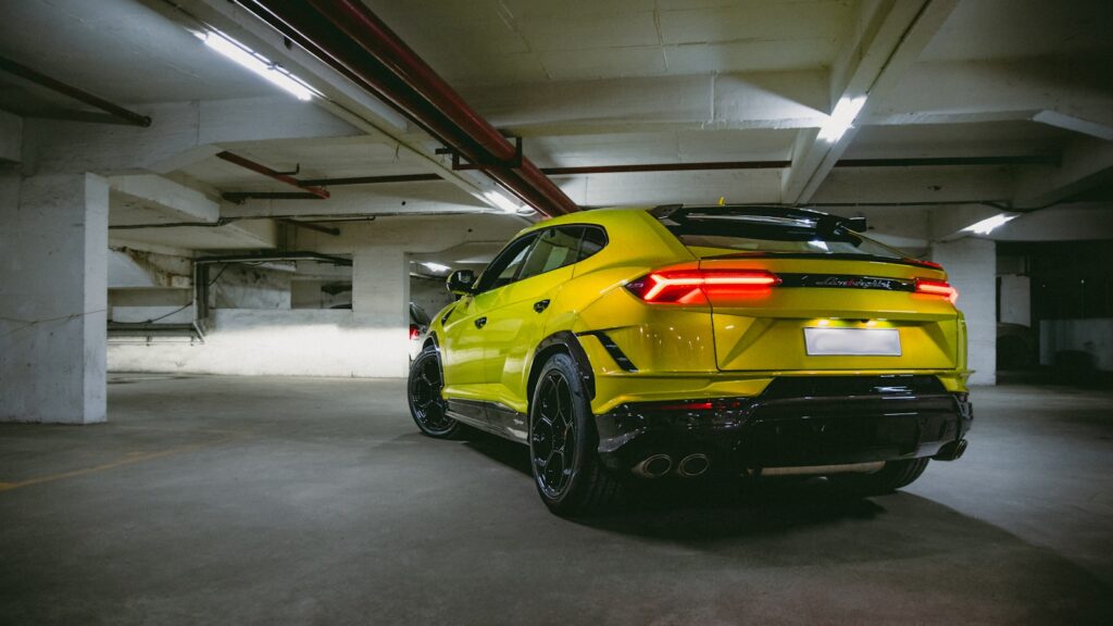 Yellow sports car parked in a dimly lit garage.