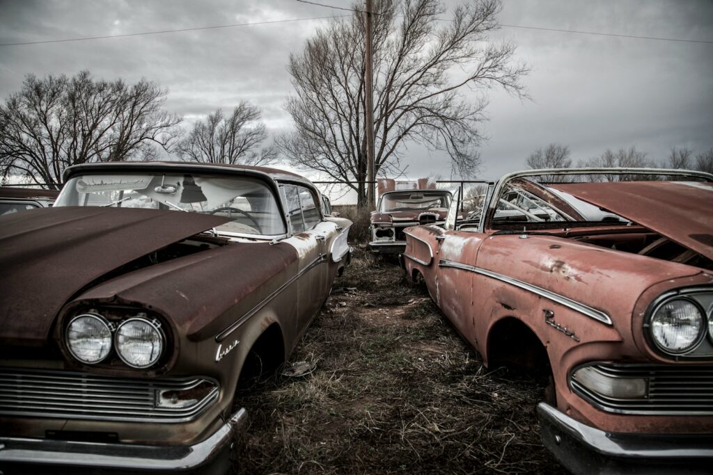 red and white vintage car parked on green grass field during daytime