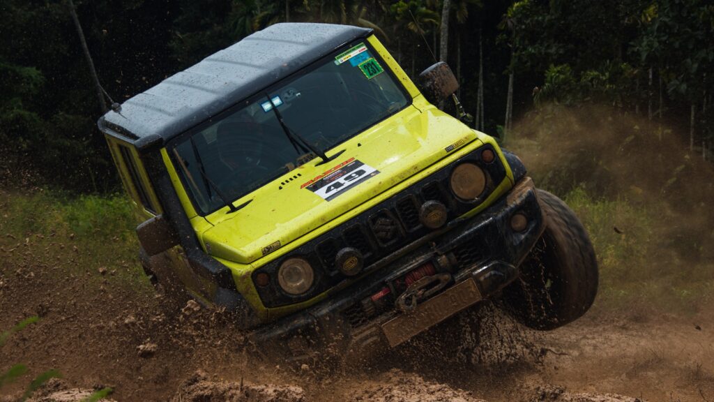 Yellow off-road vehicle driving through mud
