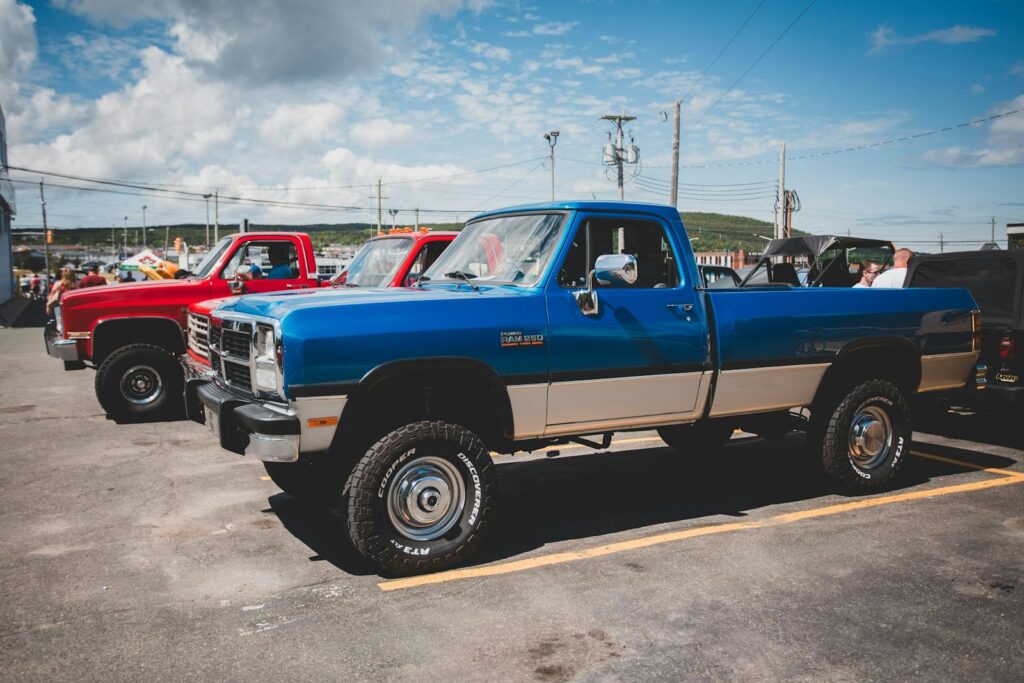 Vintage pickup trucks showcased outdoors on a sunny day.