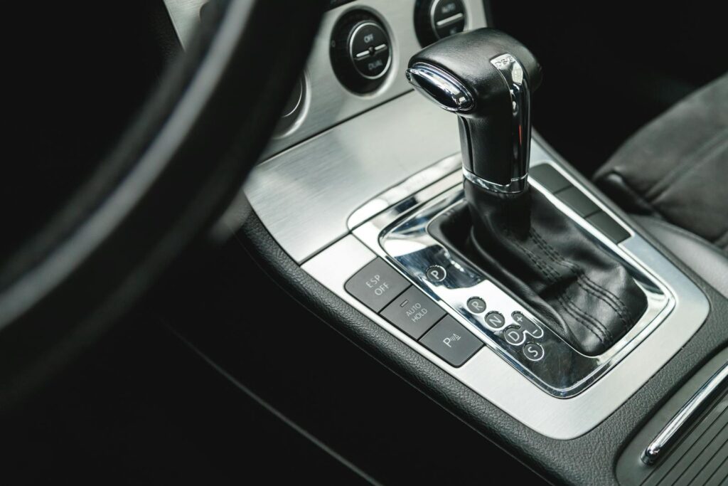 Detailed view of a modern car's automatic gear shifter inside vehicle interior.