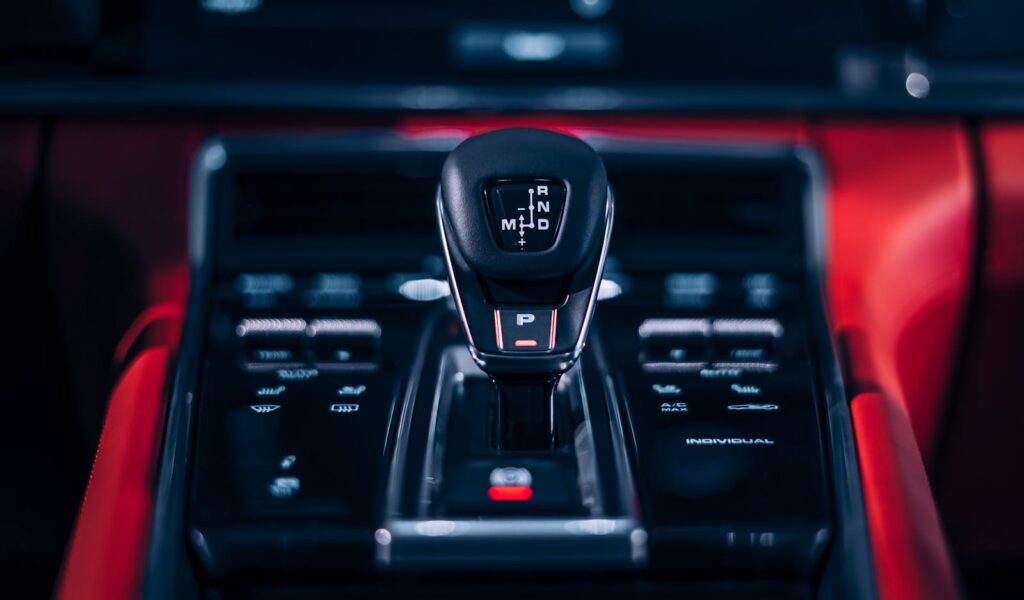 Focus on a sleek car gear shift lever in a luxury vehicle interior.