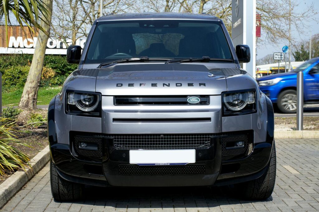Front view of a silver Land Rover Defender parked on city streets in Christchurch, UK.