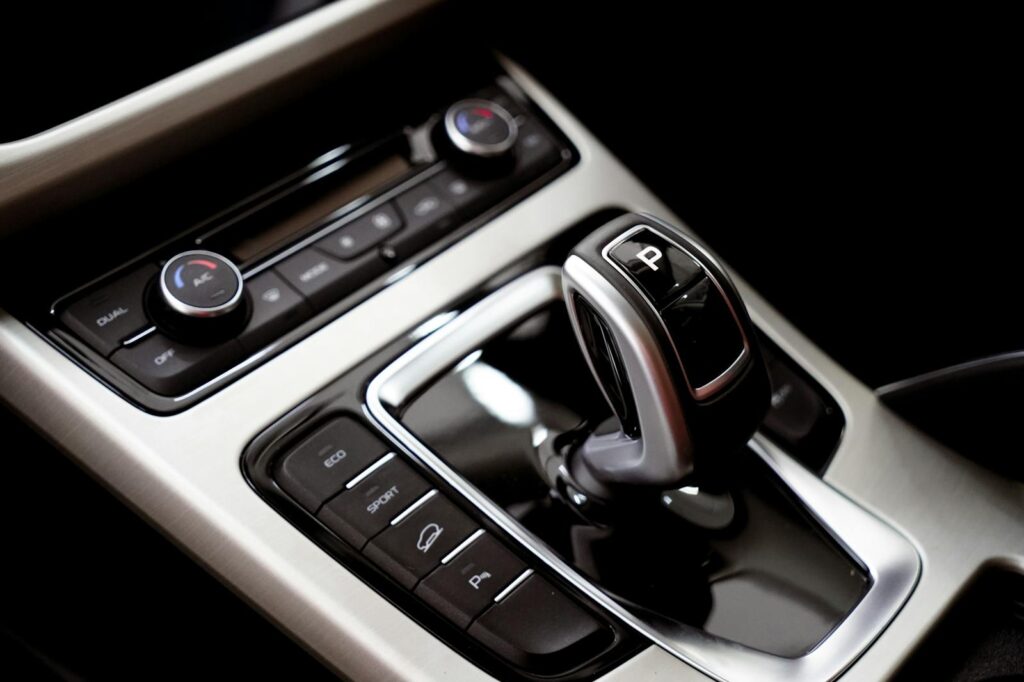 Close-up of a car's modern gear shift and central console with buttons.
