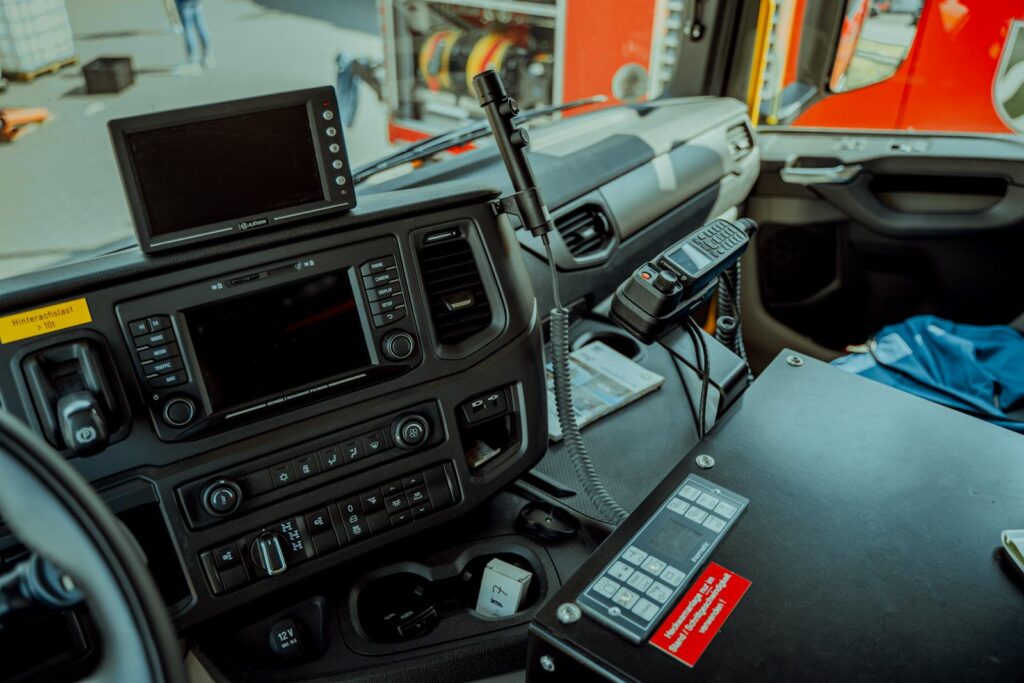 Detailed photo of a firetruck dashboard with communication devices and navigation screens.