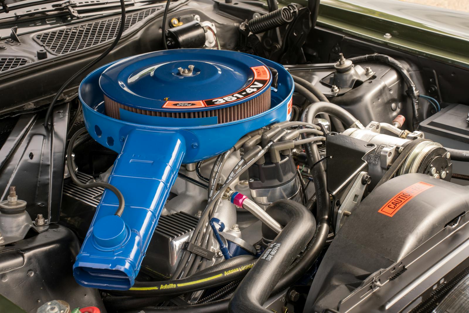Detailed image of a vintage car engine featuring a blue air filter.
