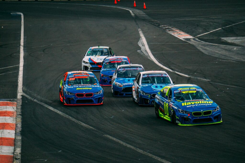 A thrilling car race with blue sports cars competing on a professional track.