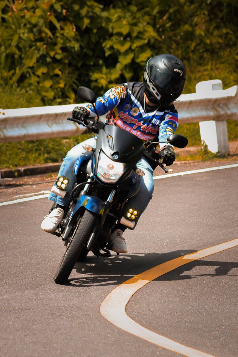 Rider on a motorcycle taking a sharp turn on a scenic outdoor road.