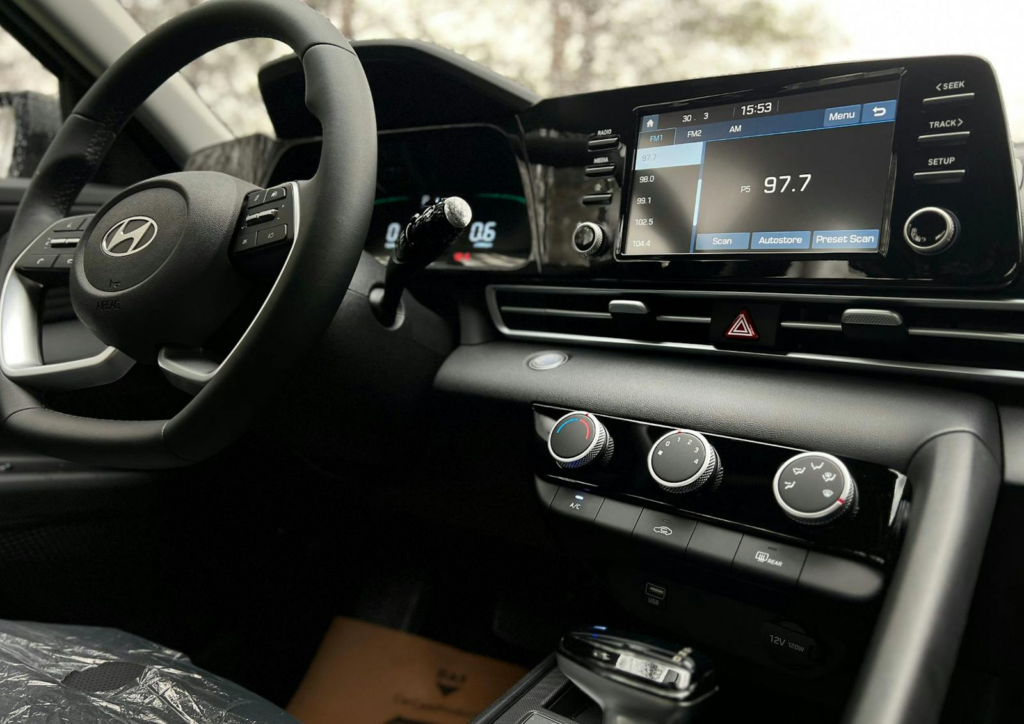 Interior view of a modern car dashboard featuring a touchscreen infotainment system and steering wheel.