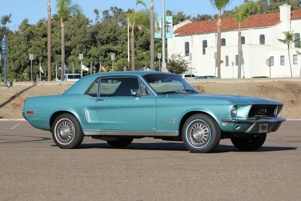 Beautiful blue 1968 Ford Mustang parked outdoors with building backdrop.