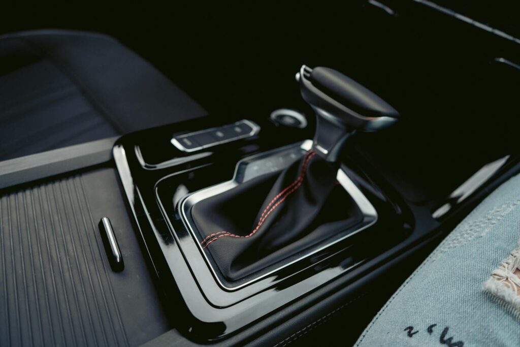 Close-up of a luxury car's interior featuring a modern gear shift with leather and chrome accents.