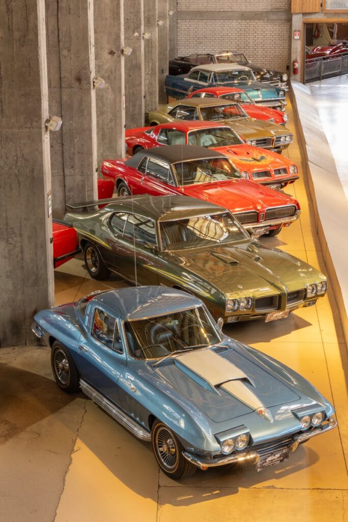 A lineup of vintage classic cars in a well-lit showroom, showcasing automotive history.