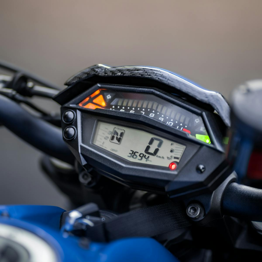 Detailed view of a motorcycle dashboard with digital screen showing speed and gear.
