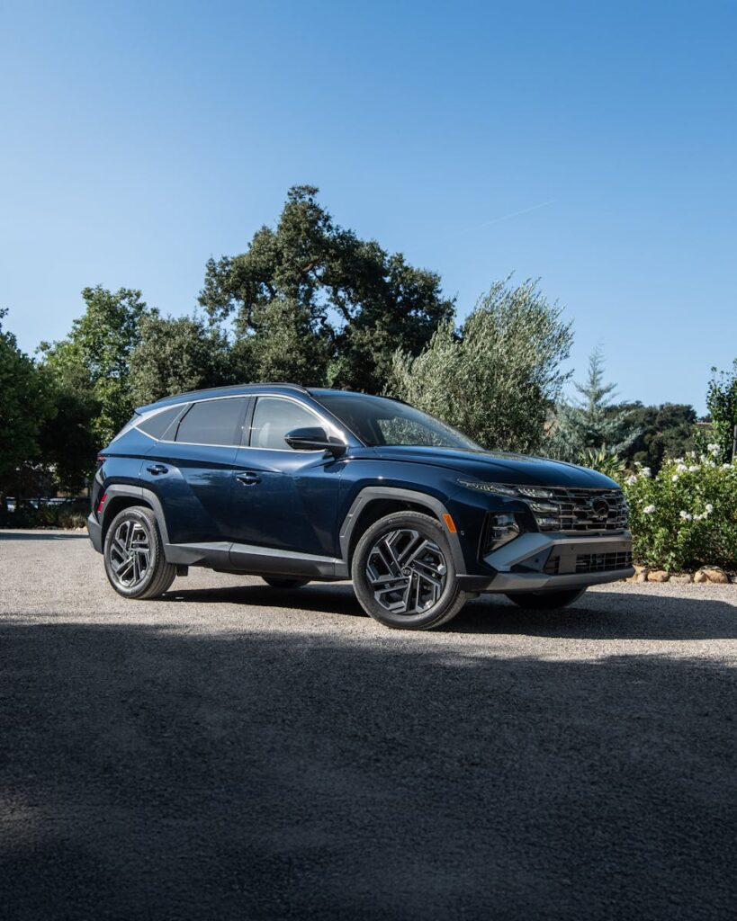 Sleek Hyundai Tucson Hybrid parked outdoors on a sunny day.