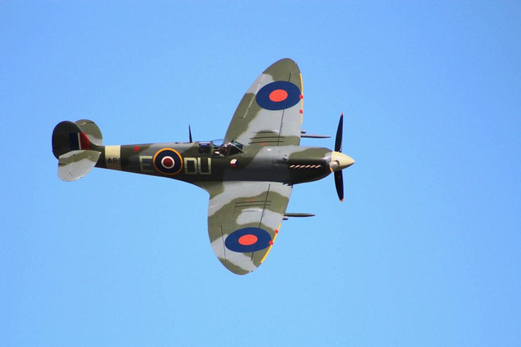 Close-up view of a vintage Spitfire aircraft in flight against a clear blue sky. Iconic WWII plane.