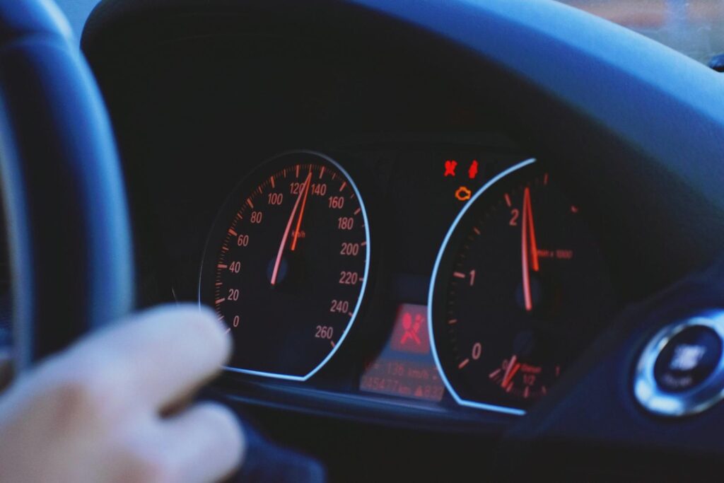 A detailed view of a car's speedometer and dashboard, emphasizing speed and technology.