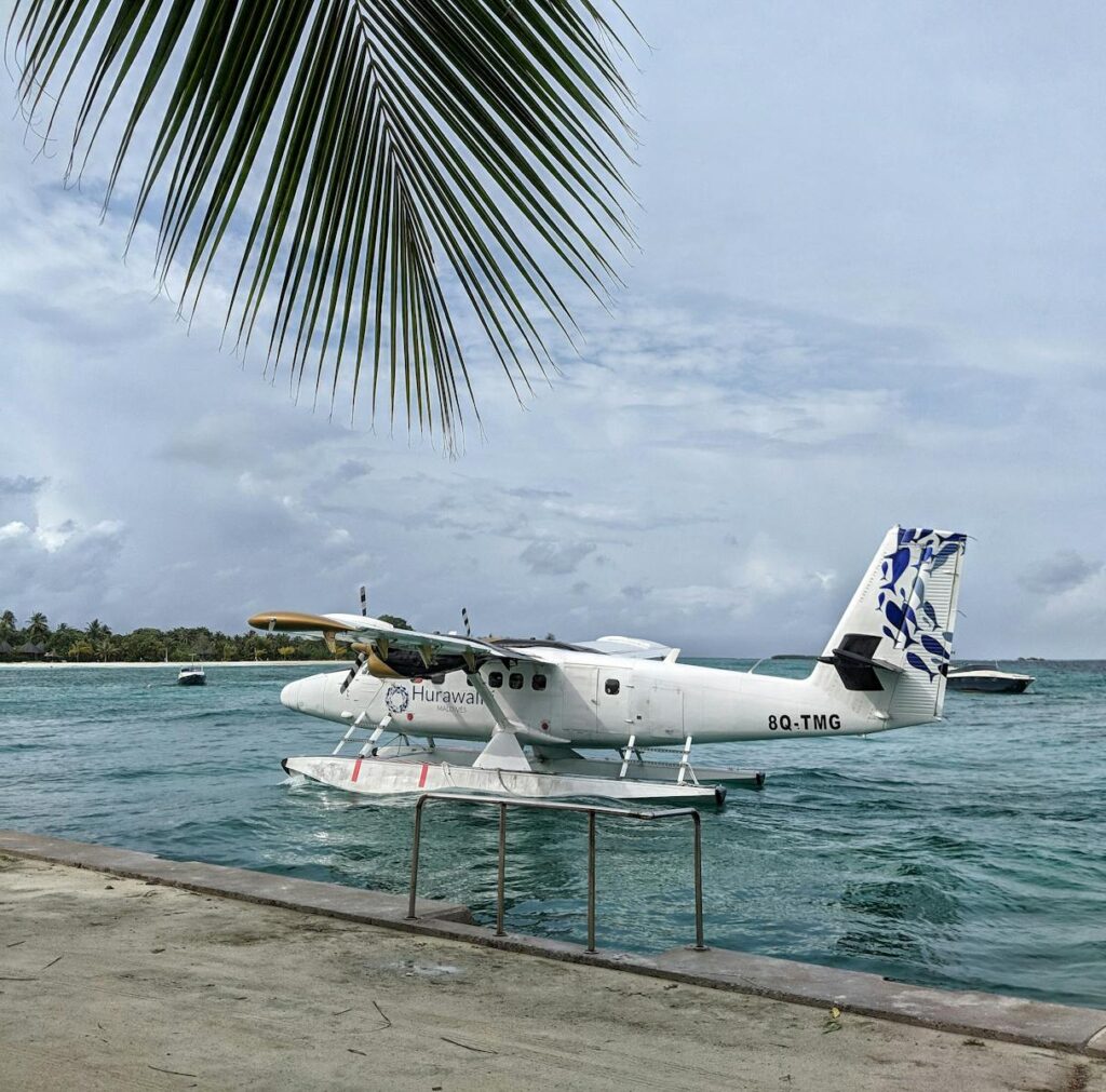 A seaplane docked at the shore of Lhaviyani Atoll, Maldives, offering serene coastal views.