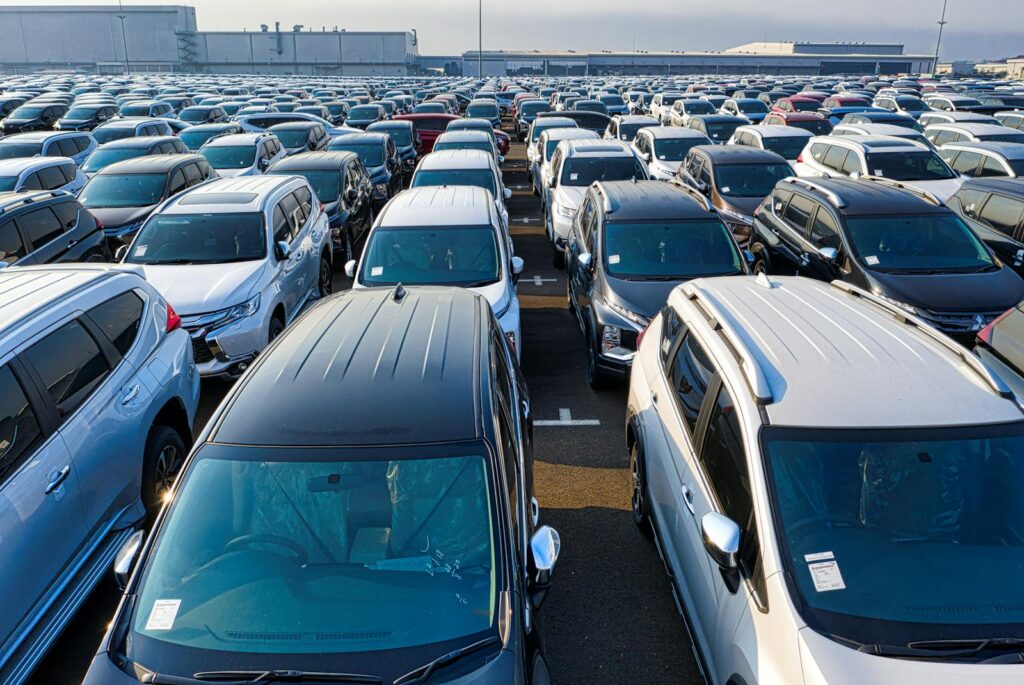 Rows of many contemporary expensive automobiles parked on asphalt of manufacture in daytime