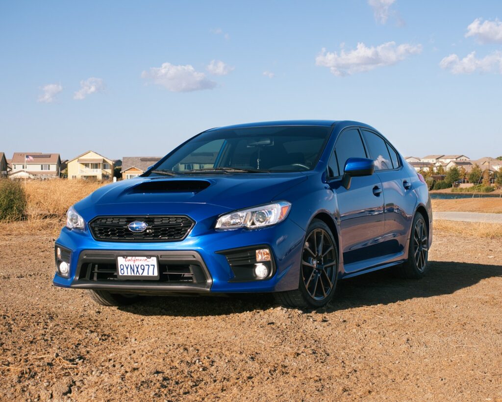 a blue car parked on a dirt road