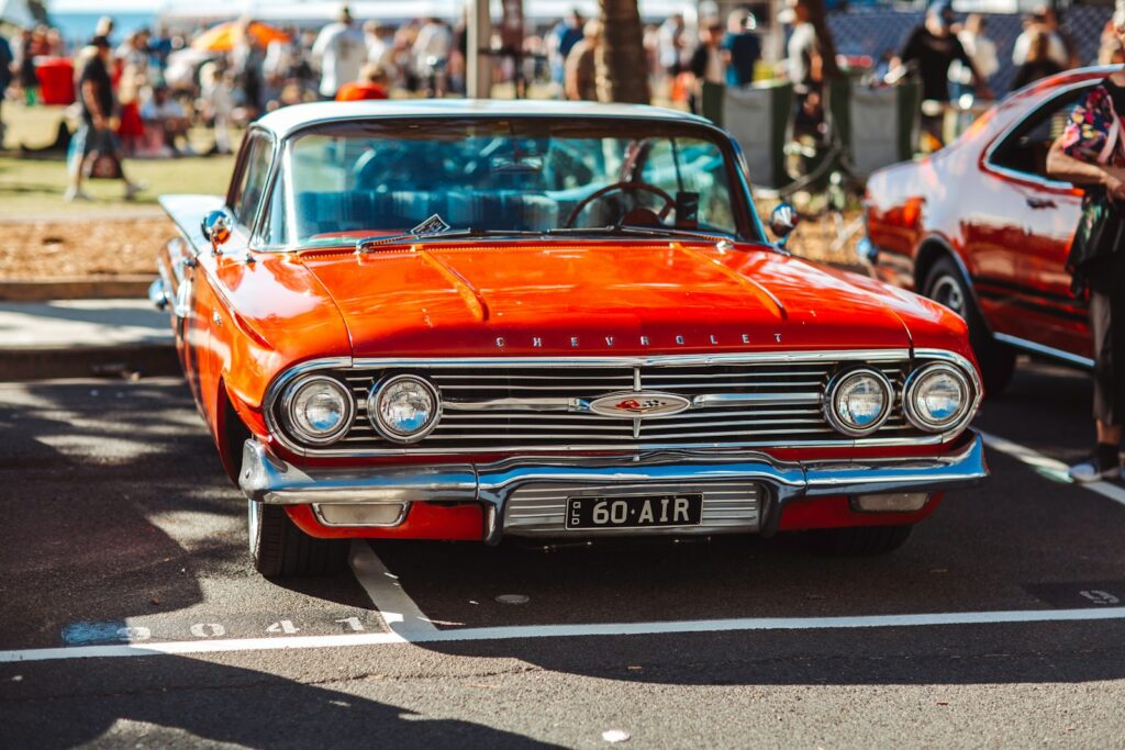an orange classic car parked in a parking lot