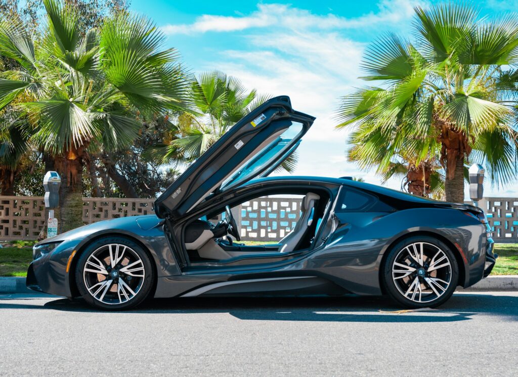 a blue sports car with its doors open