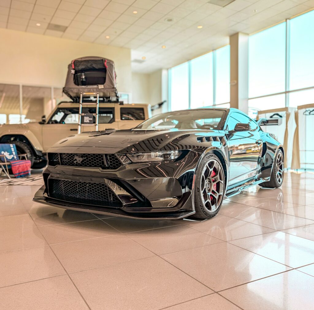 Black sports car with red brake calipers in showroom