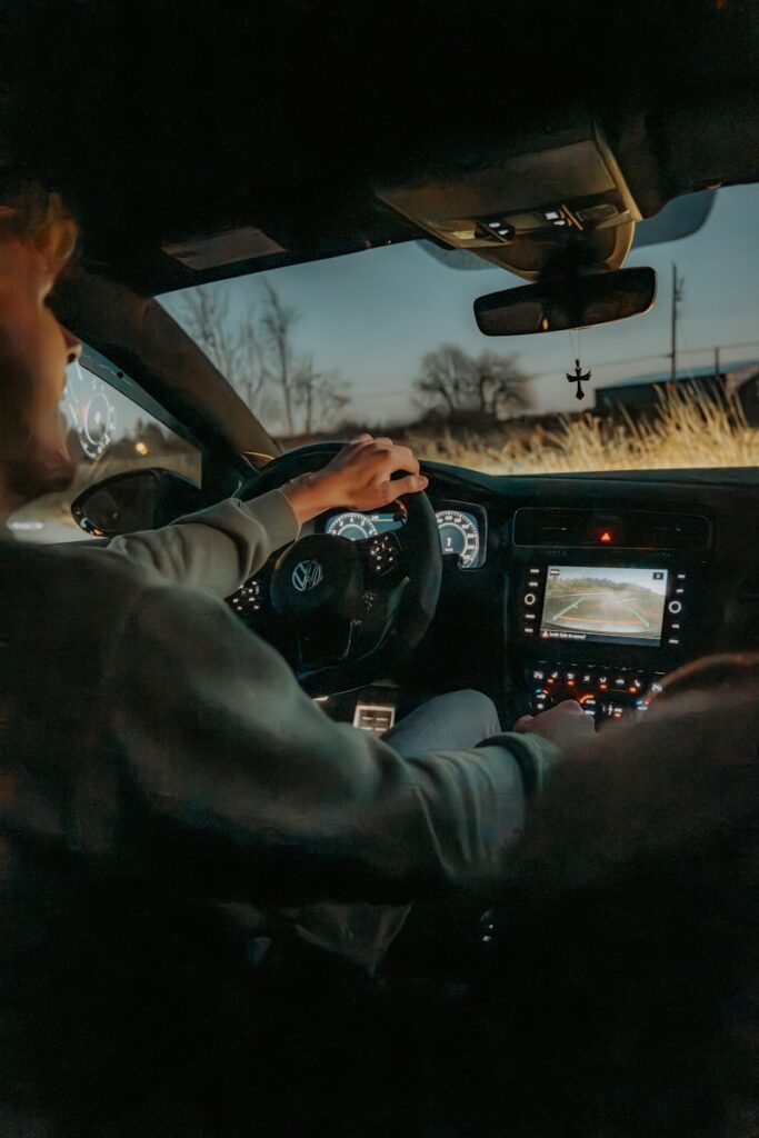 a man sitting in a car with a steering wheel
