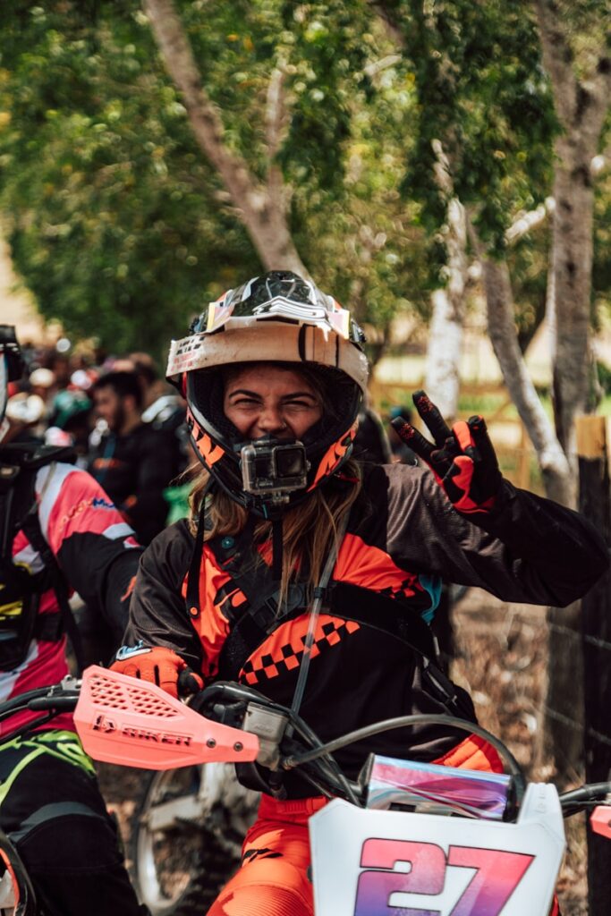 a person on a dirt bike giving the peace sign