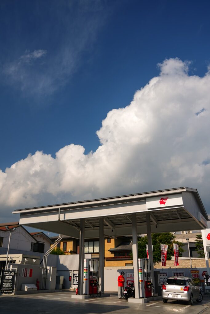 Gas station with cars under a cloudy blue sky