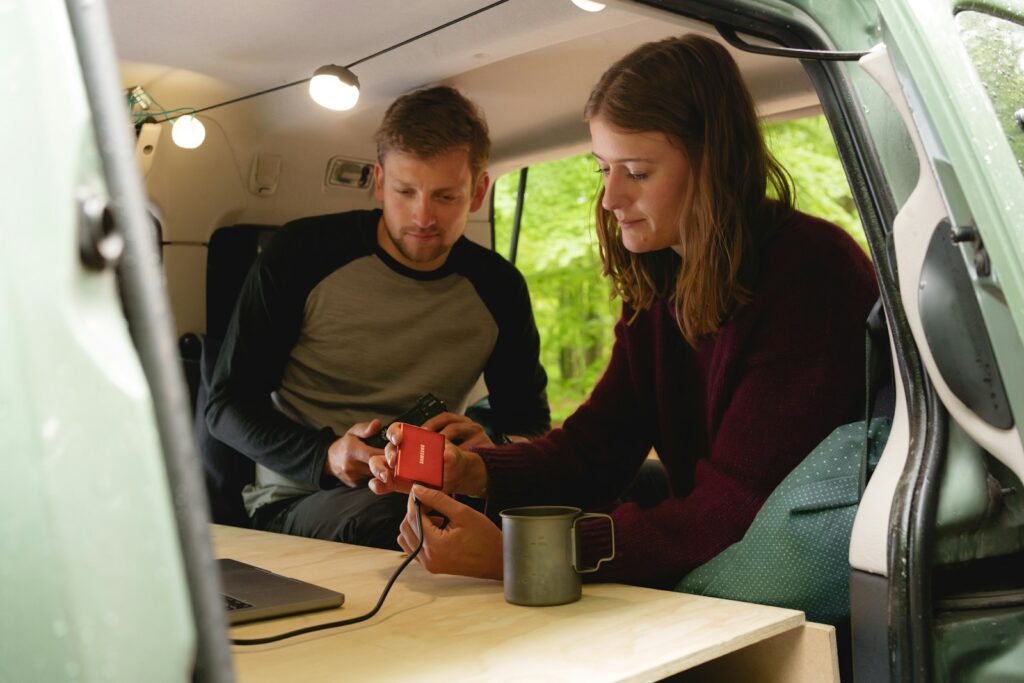 a man and a woman looking at a cell phone in a car