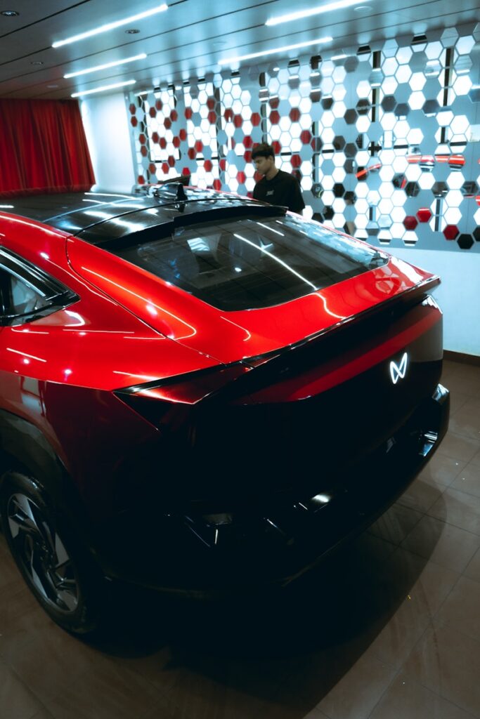 A sleek red car with a black roof and spoiler.