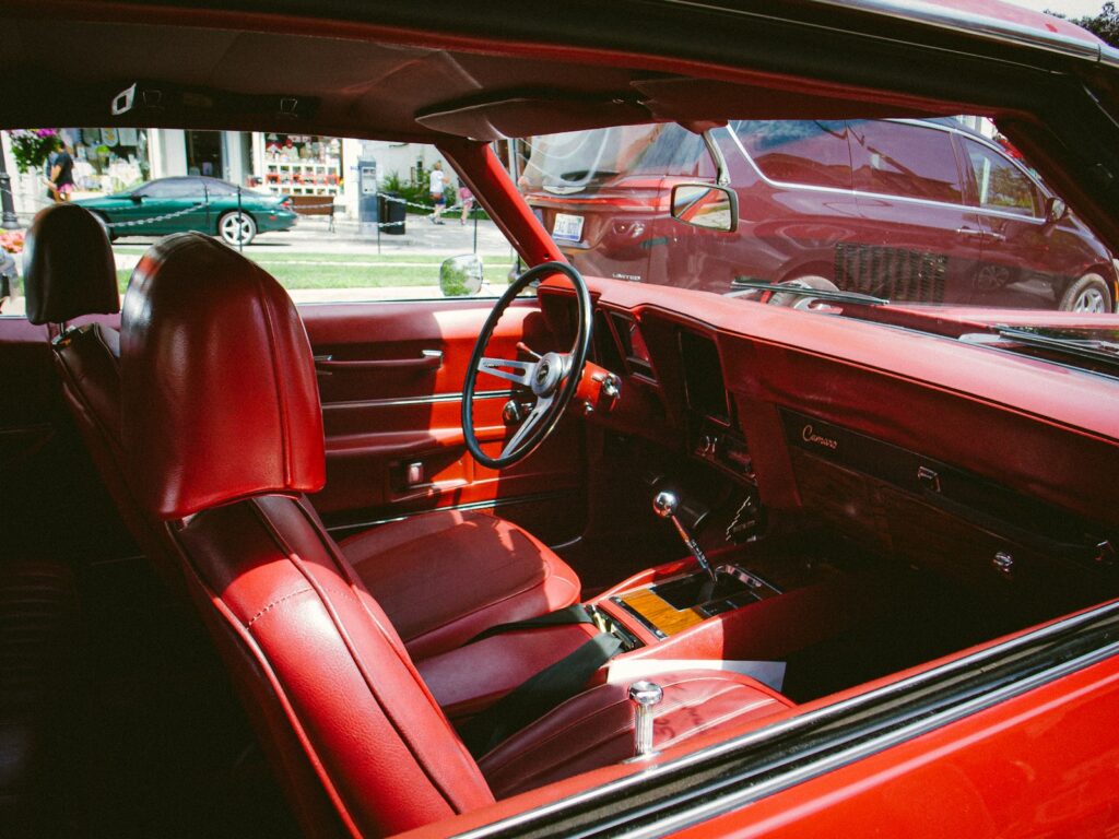The interior of a red car with a steering wheel