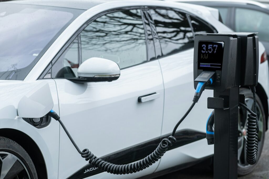 White electric car charging at a station.