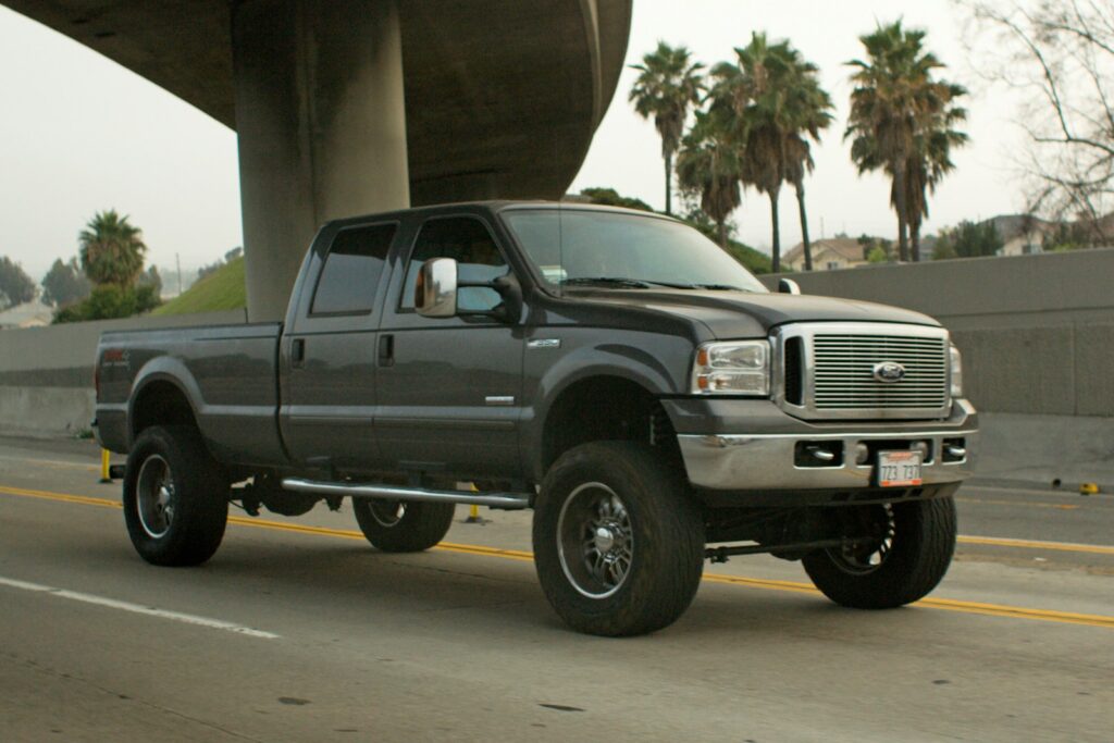 A dark gray pickup truck driving on a highway.