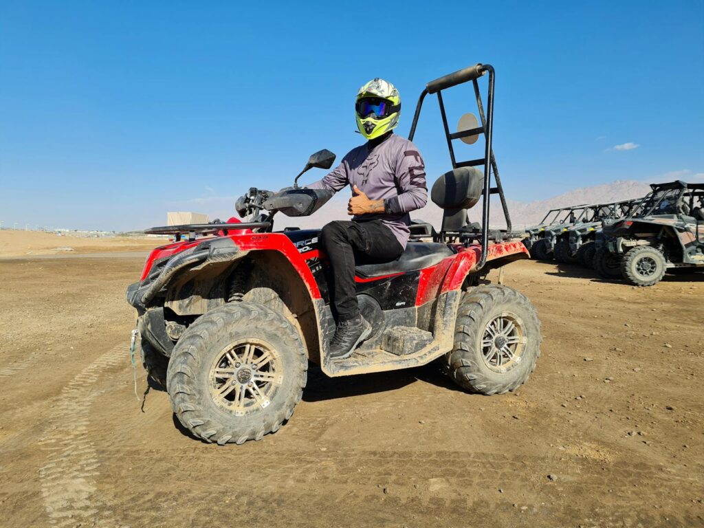 Person on an ATV giving a thumbs up gesture in the desert near Eilat, Israel.