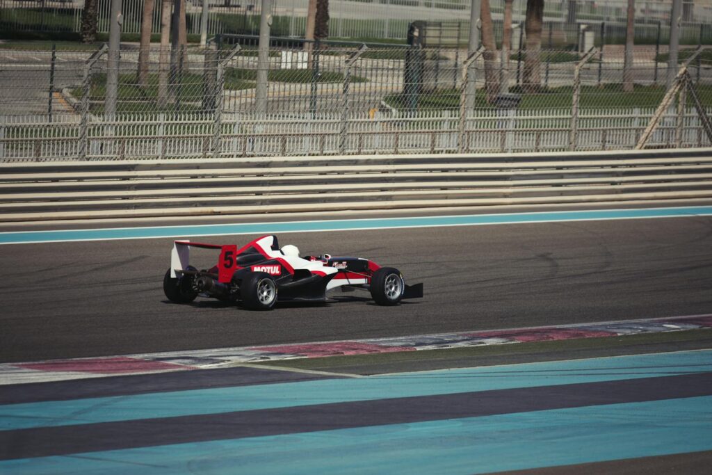 A sleek race car on Yas Marina Circuit in Abu Dhabi, showcasing speed and precision on a sunny day.