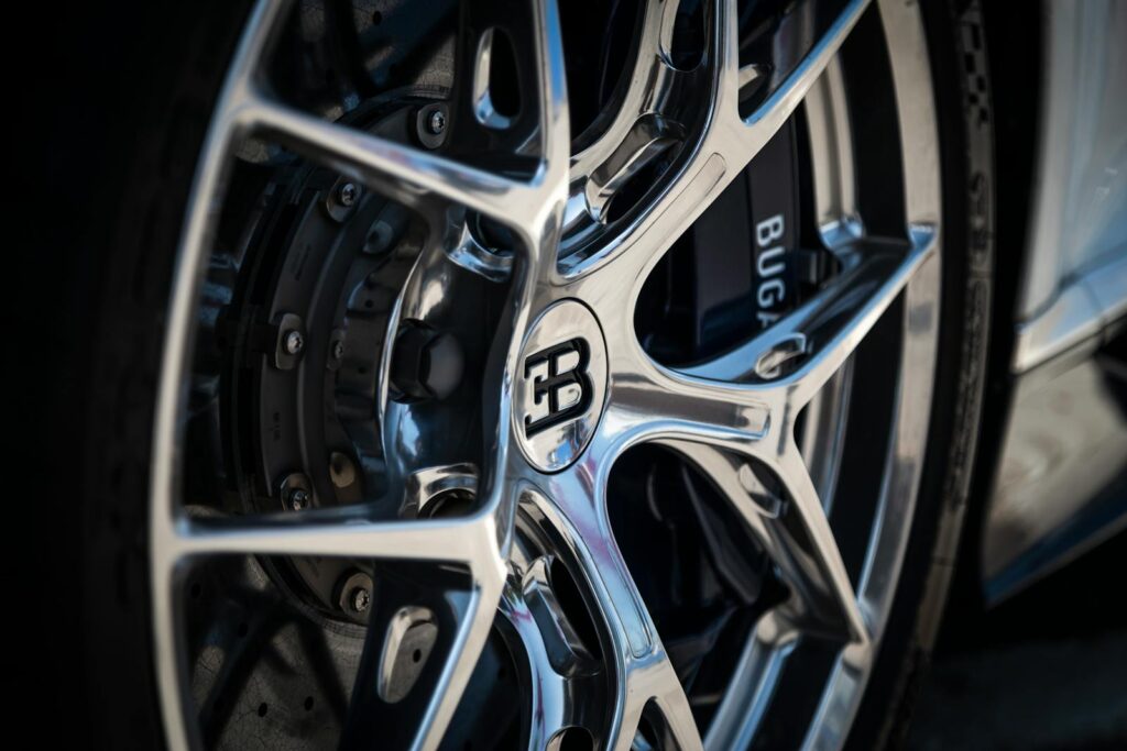 Detailed close-up of an elegant supercar wheel rim, showcasing its intricate design and reflective finish.