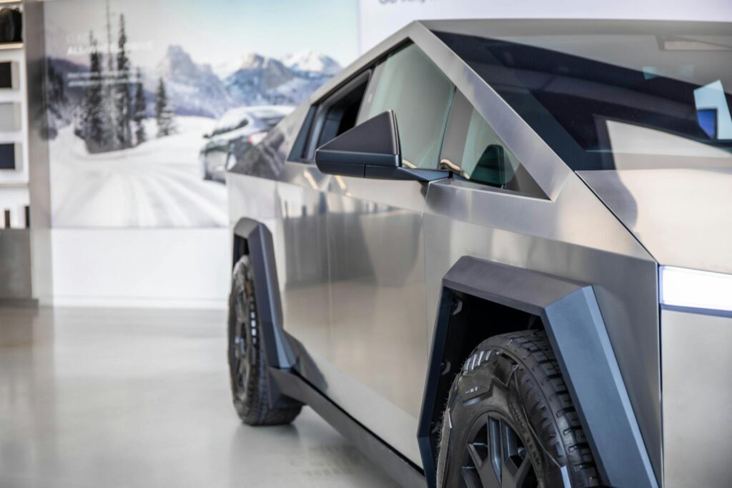 Close-up of a futuristic electric truck showcased indoors, emphasizing modern lines and design.