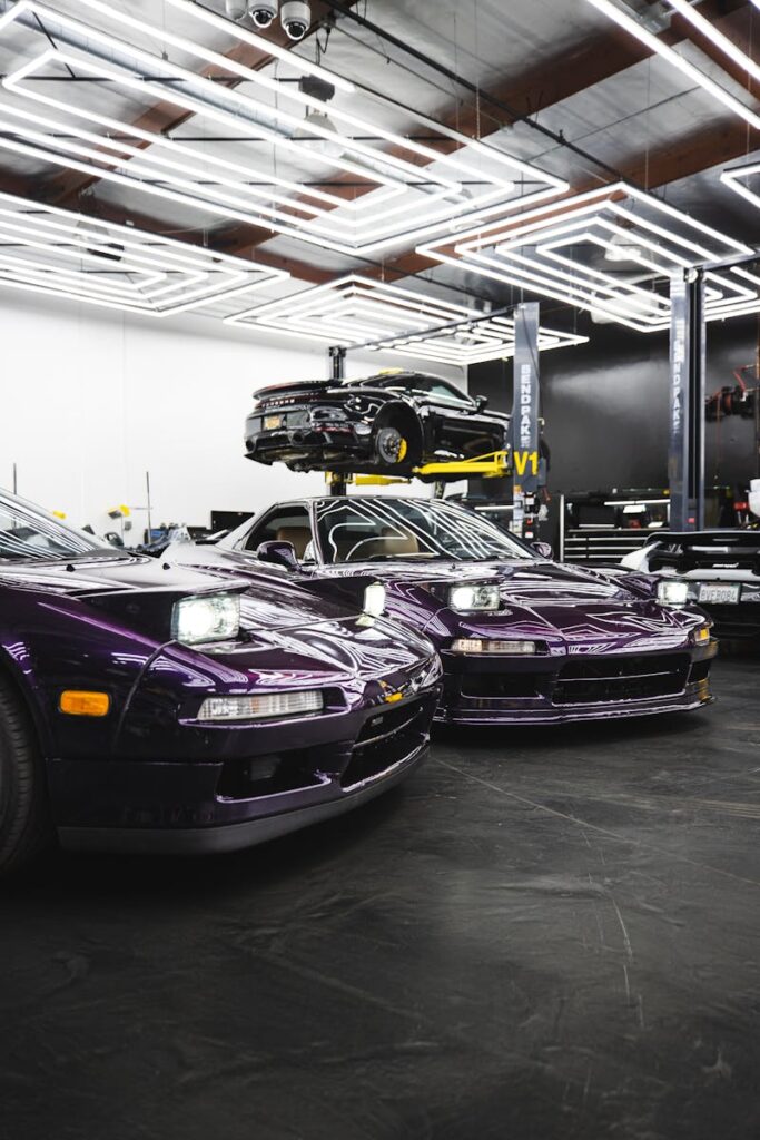 Purple sports cars showcased in a sleek, modern garage with vibrant lighting.