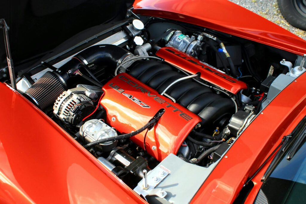 Close-up of a powerful Corvette engine with red accents, showcasing automotive engineering.