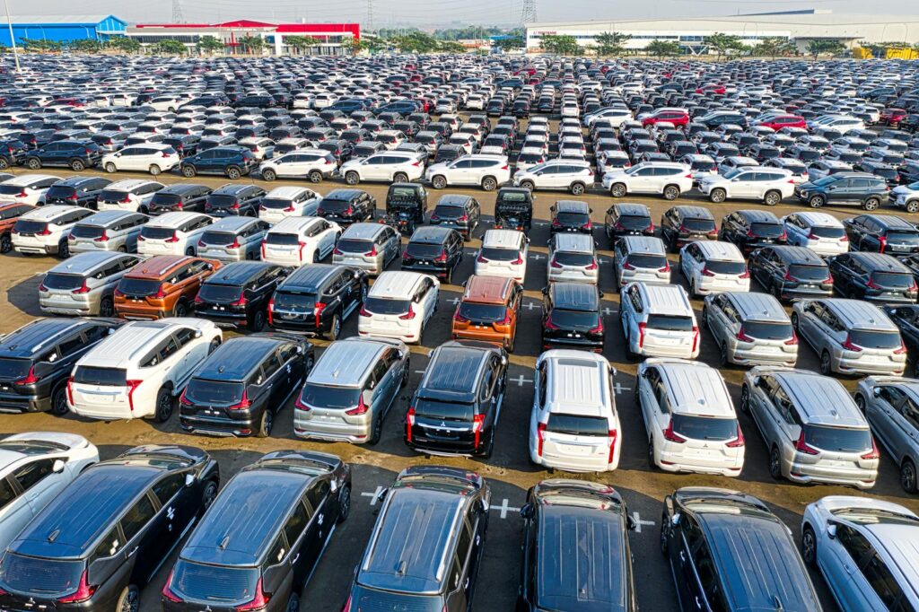 From above of rows with many modern new shiny automobiles of contemporary industry in daytime