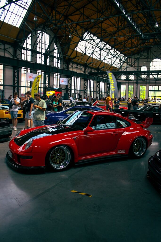 Red sports car at an indoor car show.