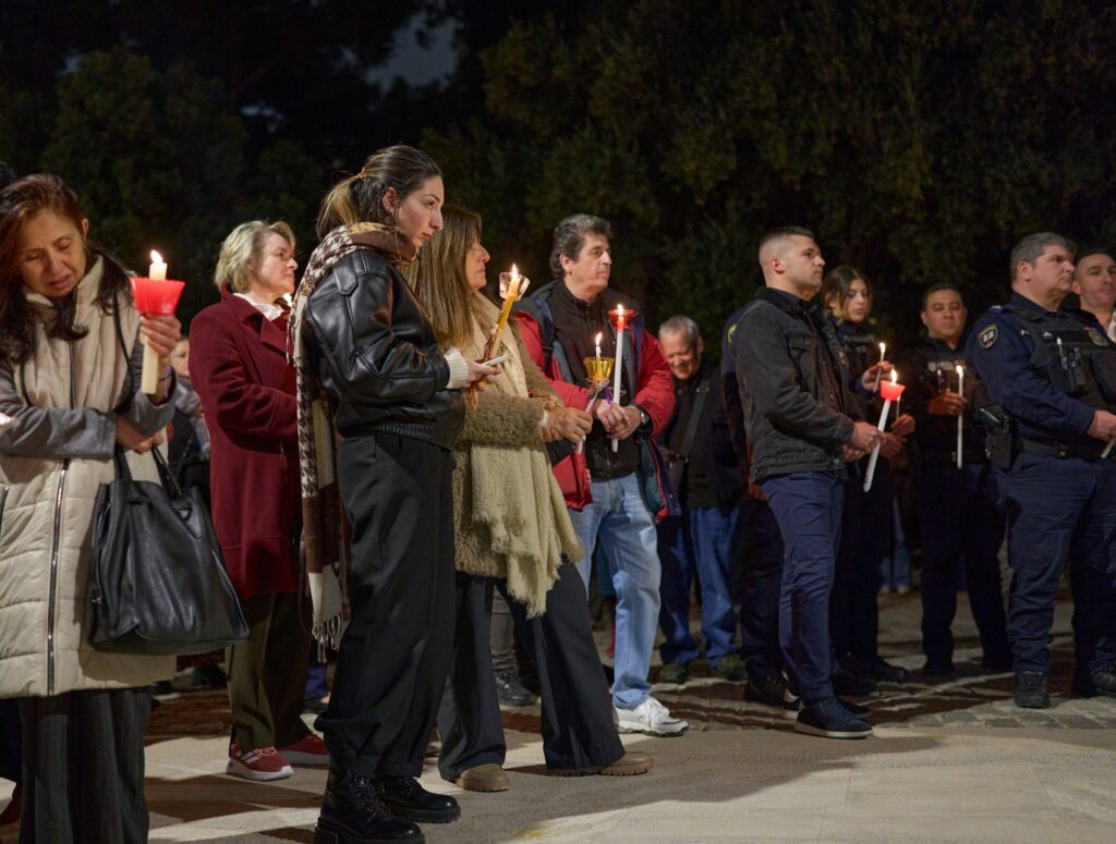 People holding candles during a vigil at night vigil