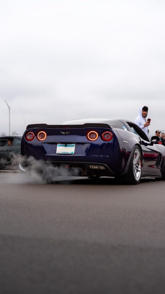 A blue sports car with smoke coming out of it