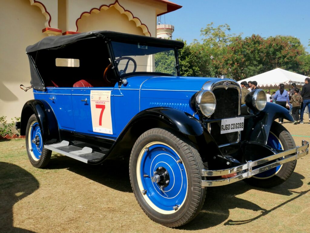 Vintage blue convertible car with black top and white accents.