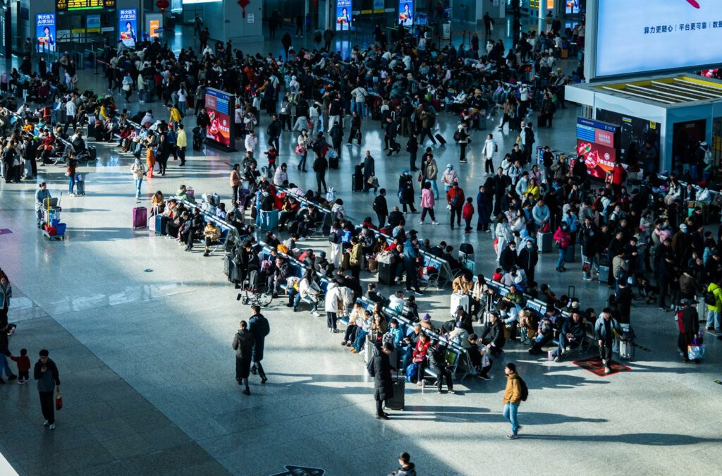 Crowded airport terminal with people waiting in line.