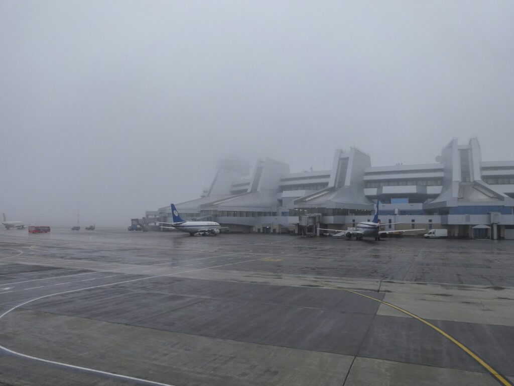 Airport terminal in foggy weather with airplanes