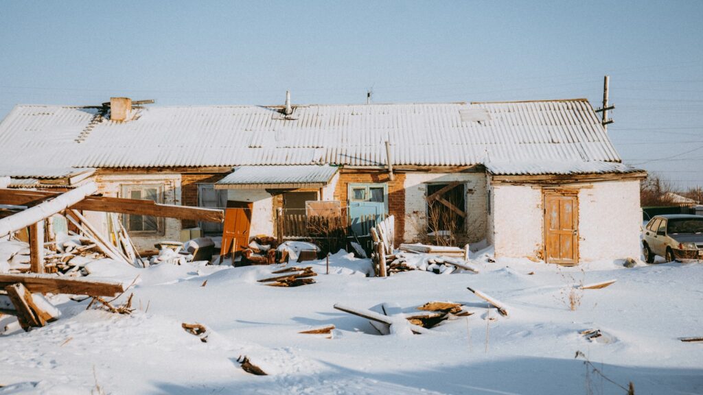 an old run down house in the snow