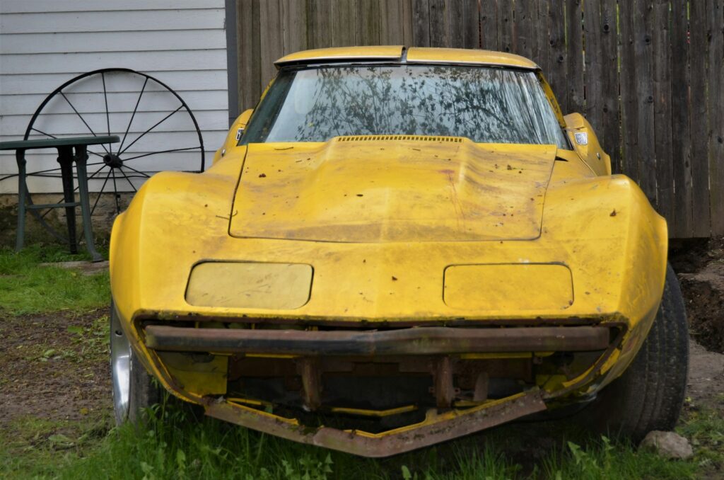 yellow car parked near white house