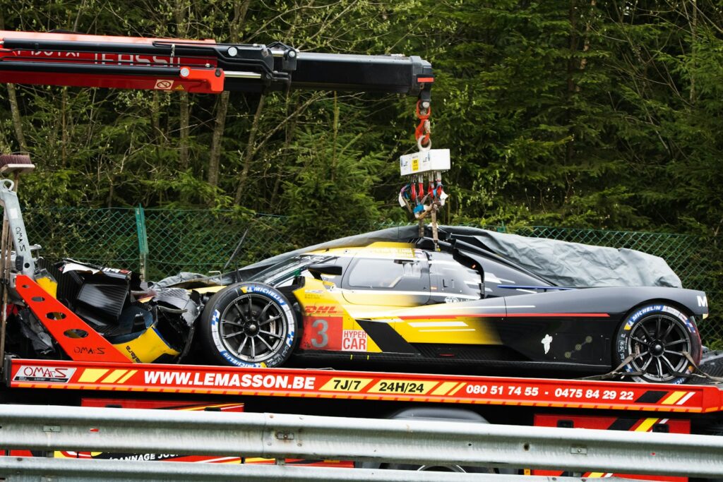 a car being lifted onto a truck by a crane